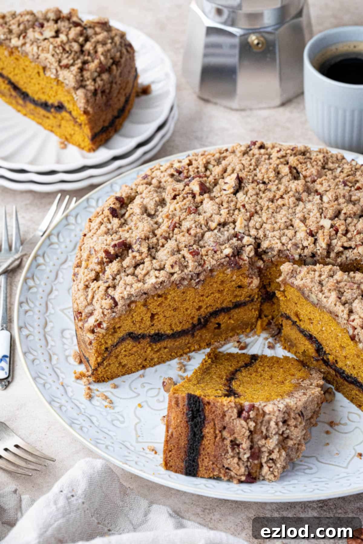 Sliced vegan pumpkin coffee cake on a white plate, ready to be served.