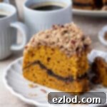 A slice of vegan pumpkin coffee cake with a forkful removed.