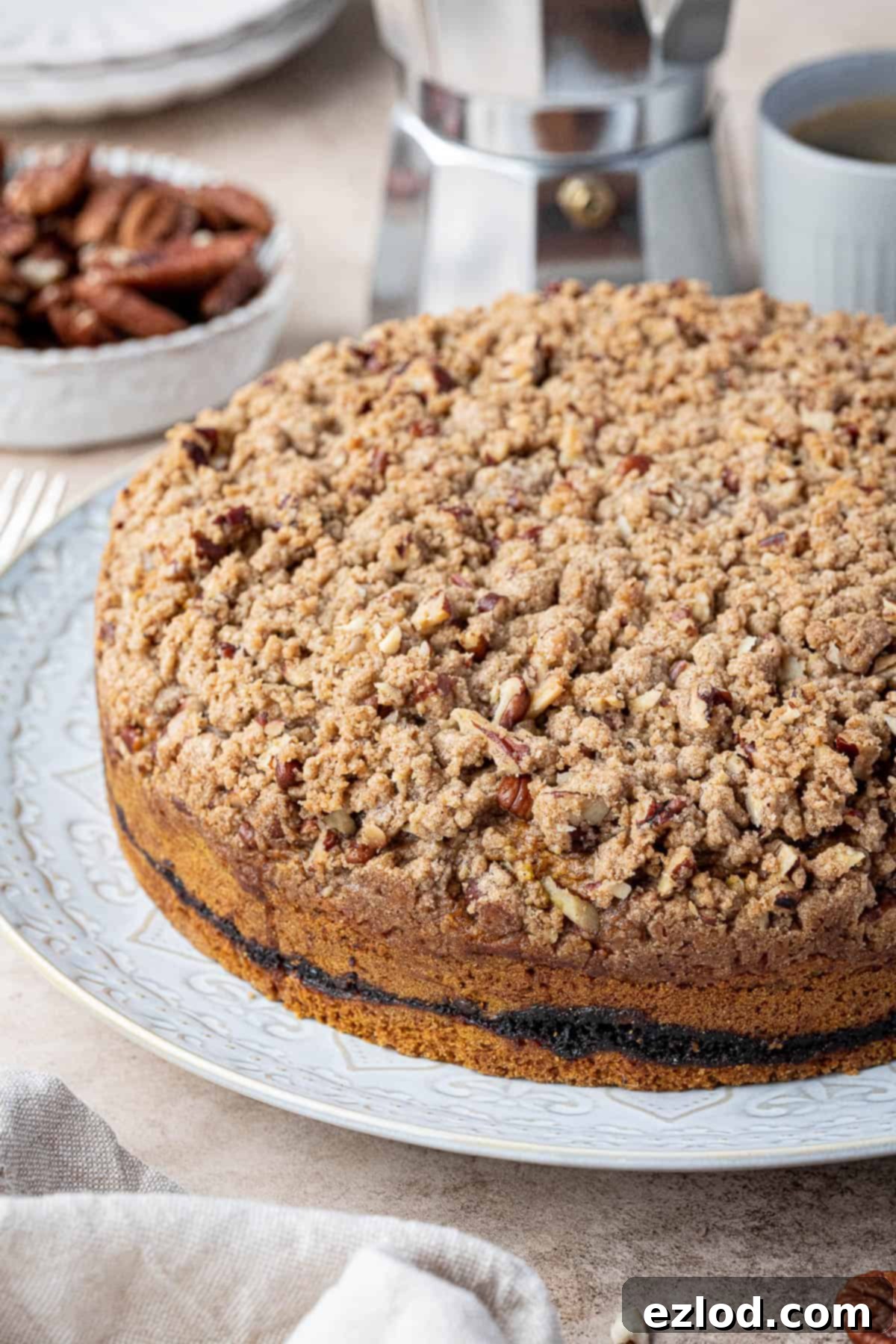 Side view of the unsliced, baked vegan pumpkin coffee cake, showing the streusel topping and the golden-brown crust.