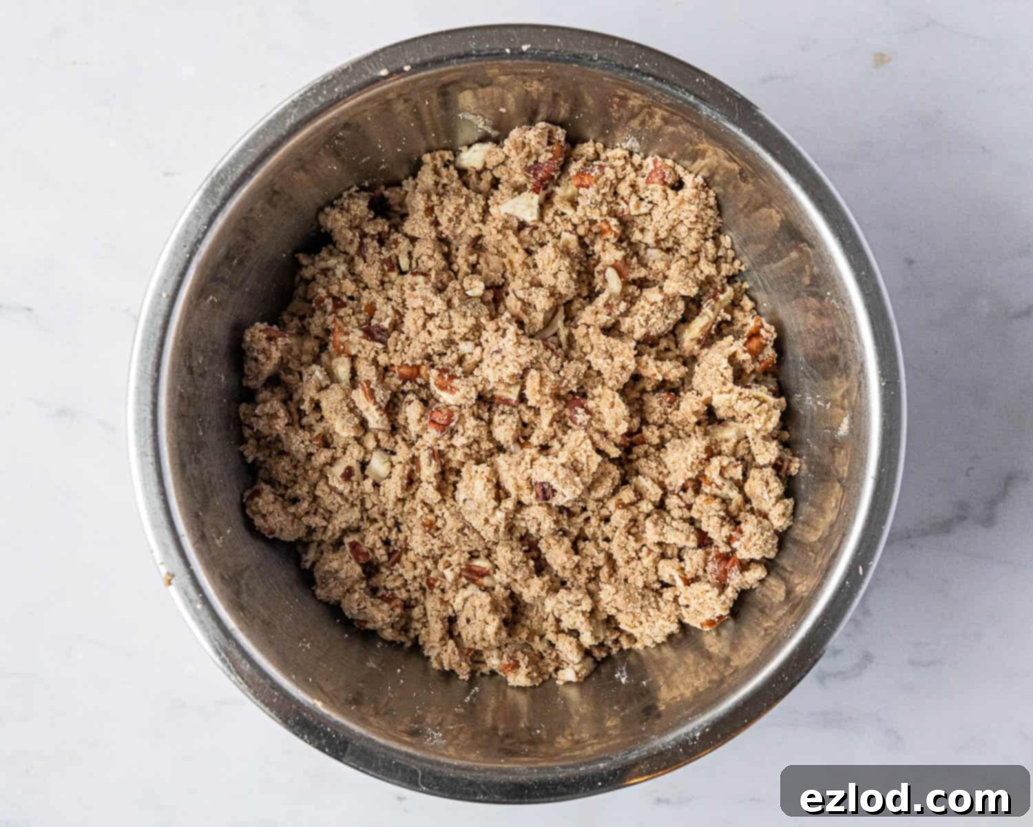 Step-by-step image of preparing the streusel topping, showing the ingredients mixed to a breadcrumb-like consistency.