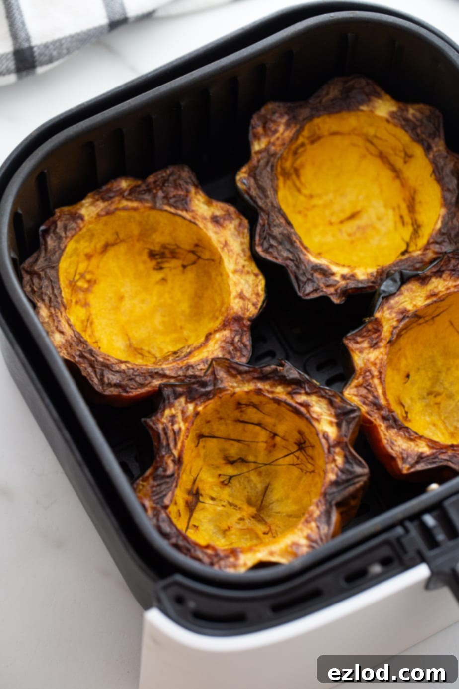 Overhead image: 4 crispy acorn squash halves in the air fryer