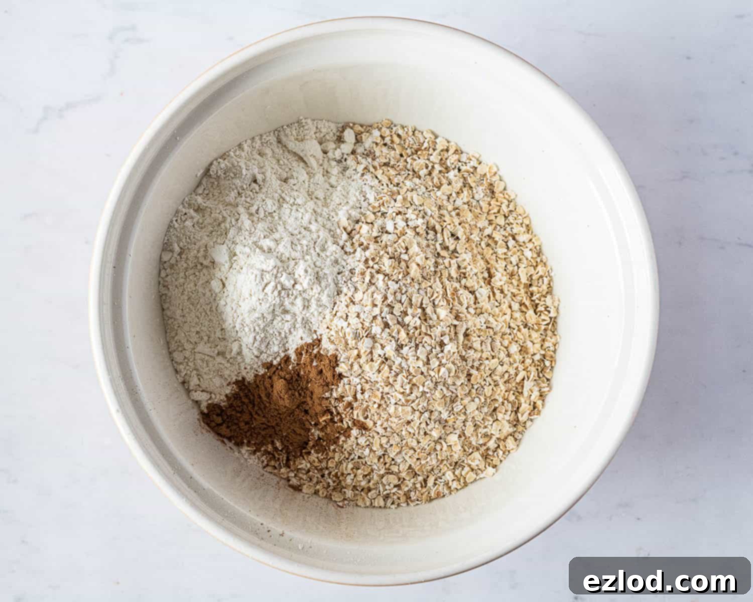 Step 1: Dry ingredients (oats, flour, cinnamon) mixed in a large bowl.