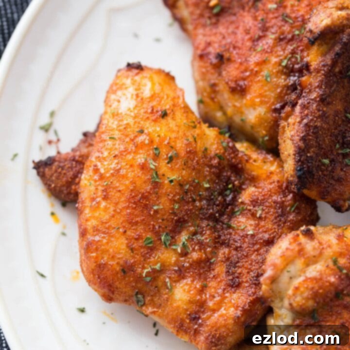 Crispy, golden-brown Air Fryer Chicken Thighs served with fresh herbs.