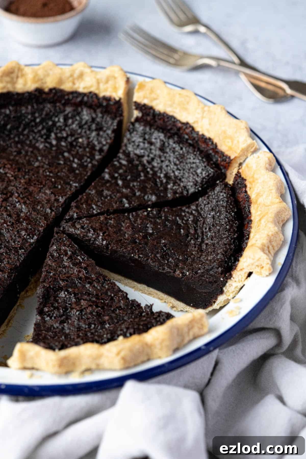 A close-up shot of a perfectly sliced vegan chocolate chess pie, showcasing its fudgy interior and crisp crust.