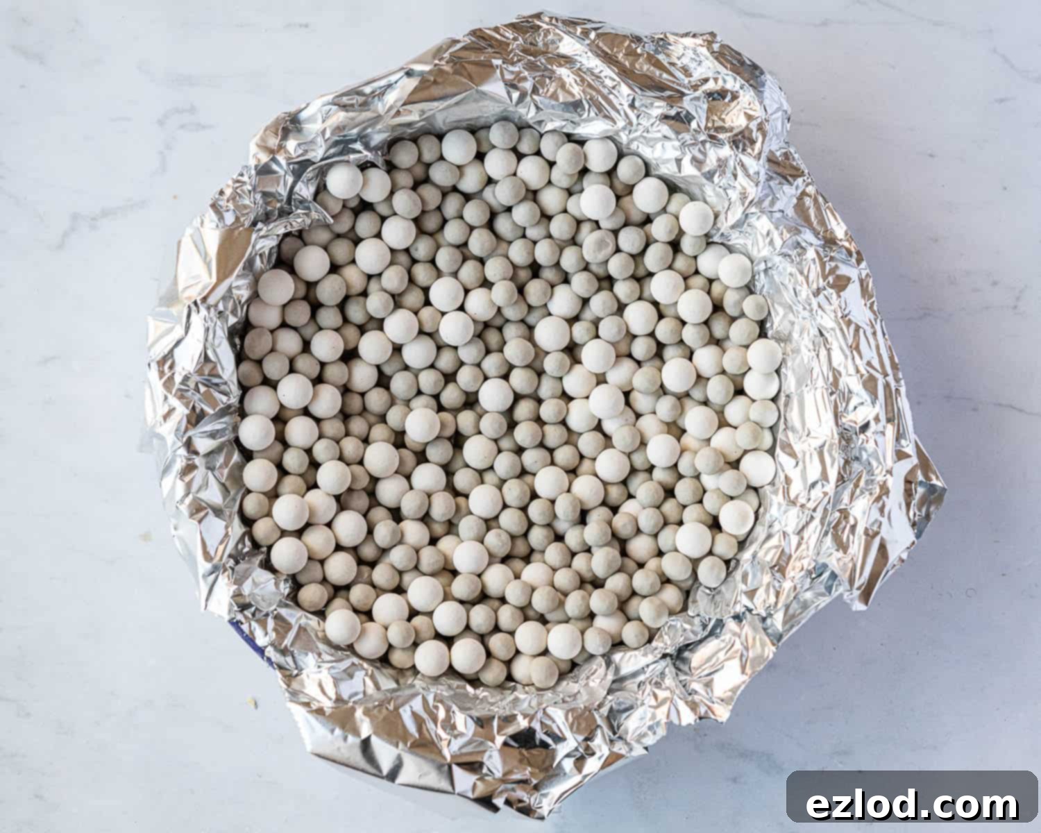 Step 3: The pie crust filled with foil and baking beans, prepared for blind baking to ensure a perfectly crisp base.