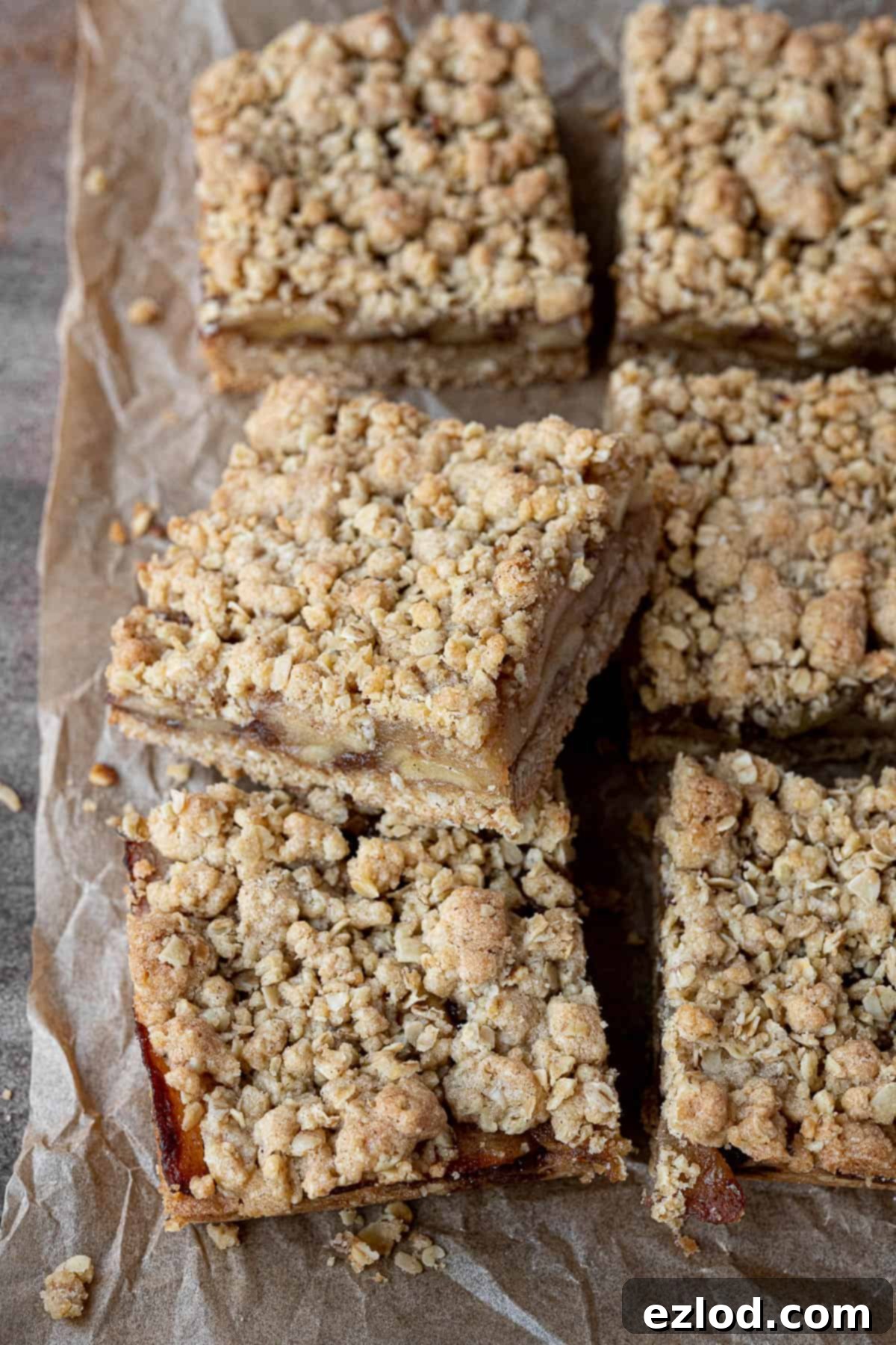 Close-up of freshly baked vegan apple crumble bars, showing the golden, crisp topping and the soft, spiced apple filling.