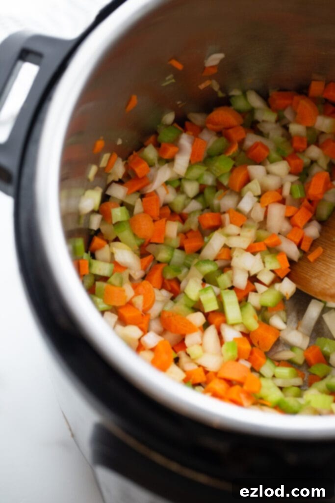 Overhead photo of chopped carrots, celery, and onion in an instant pot.