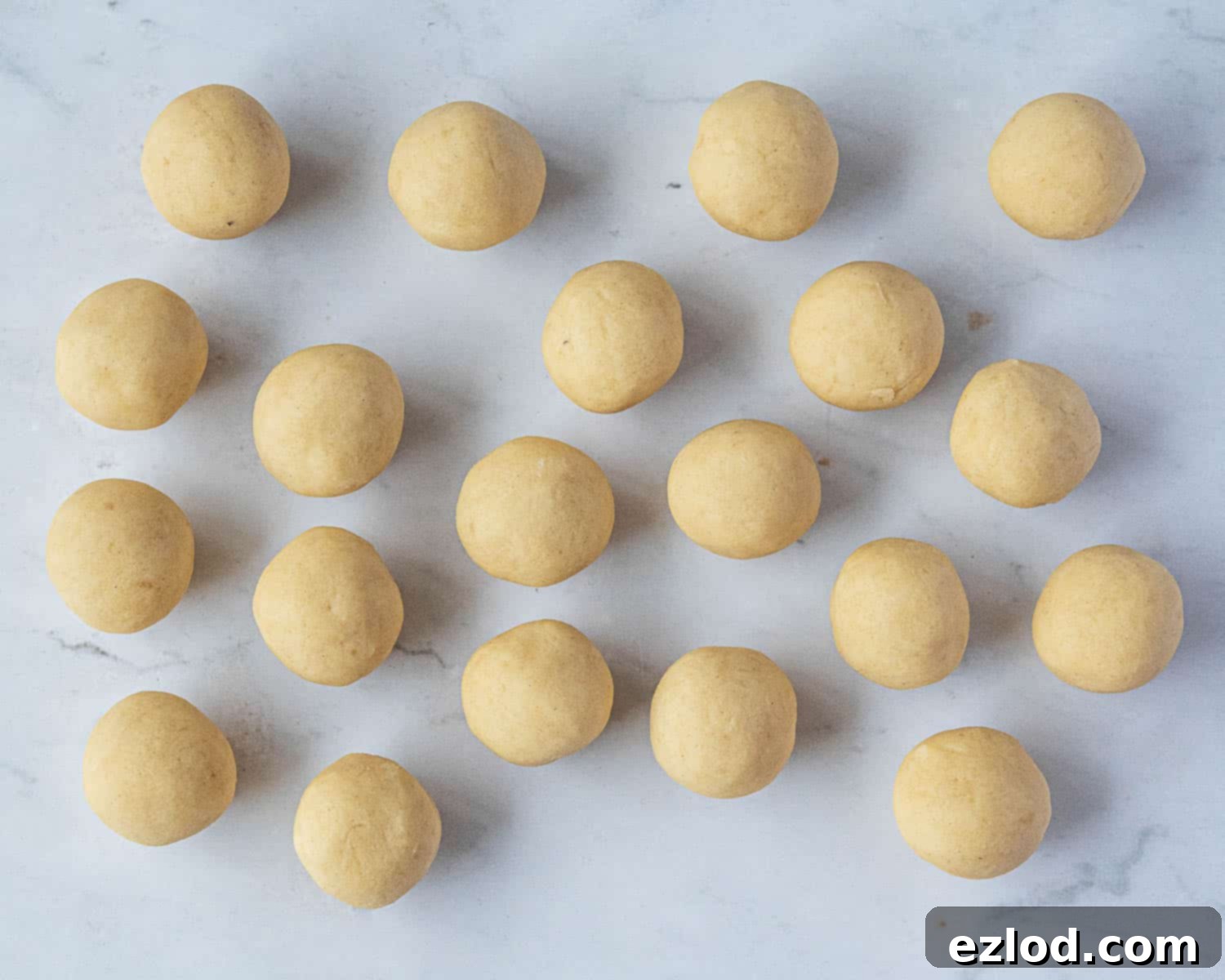 The vegan Vanillekipferl dough divided into 20 equal balls, ready for shaping.