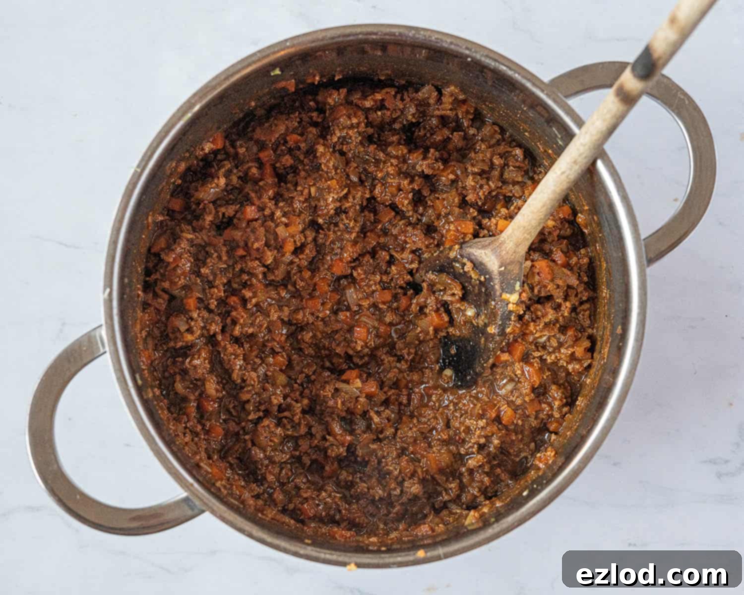 Step 3: TVP added to the wet ingredients and vegetables in a pan for vegan seitan meatloaf.