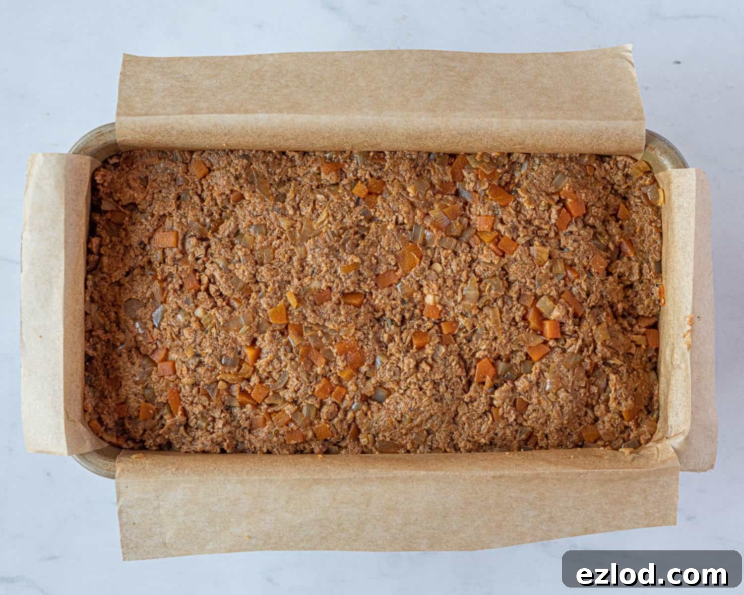 Step 5: The vegan seitan meatloaf mixture pressed into a lined loaf tin, ready for baking.