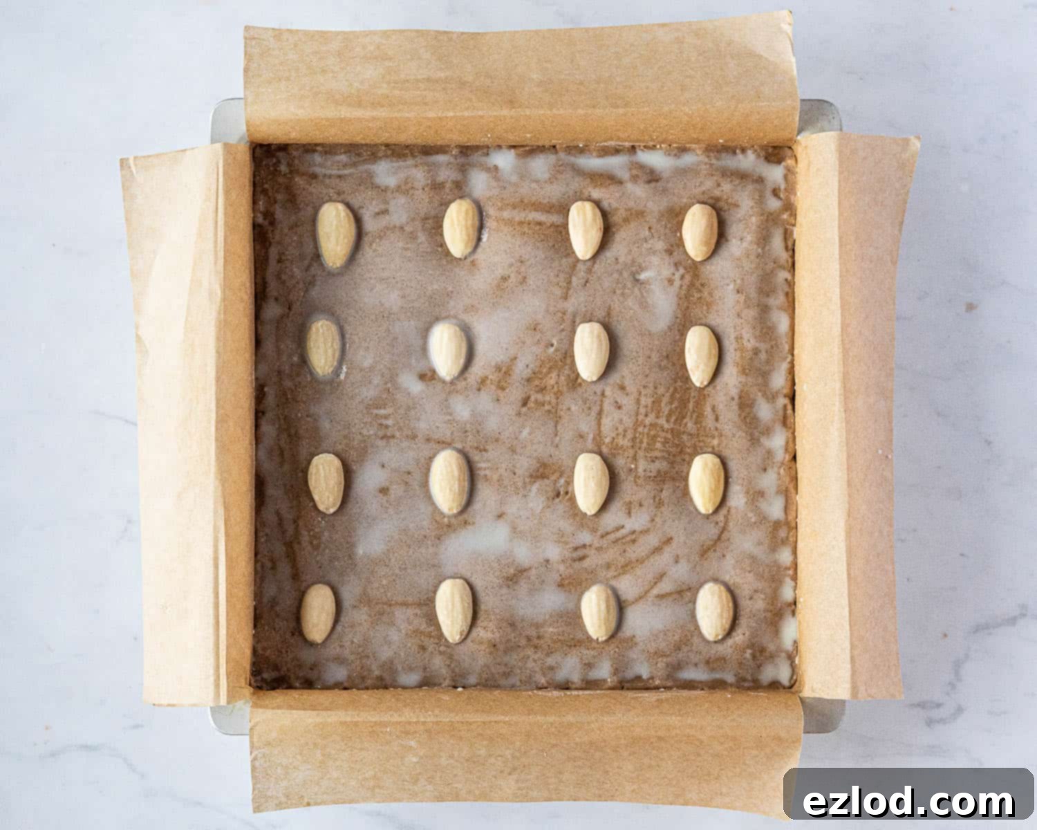 Step 7, brushing the dough with milk and adding the almonds.