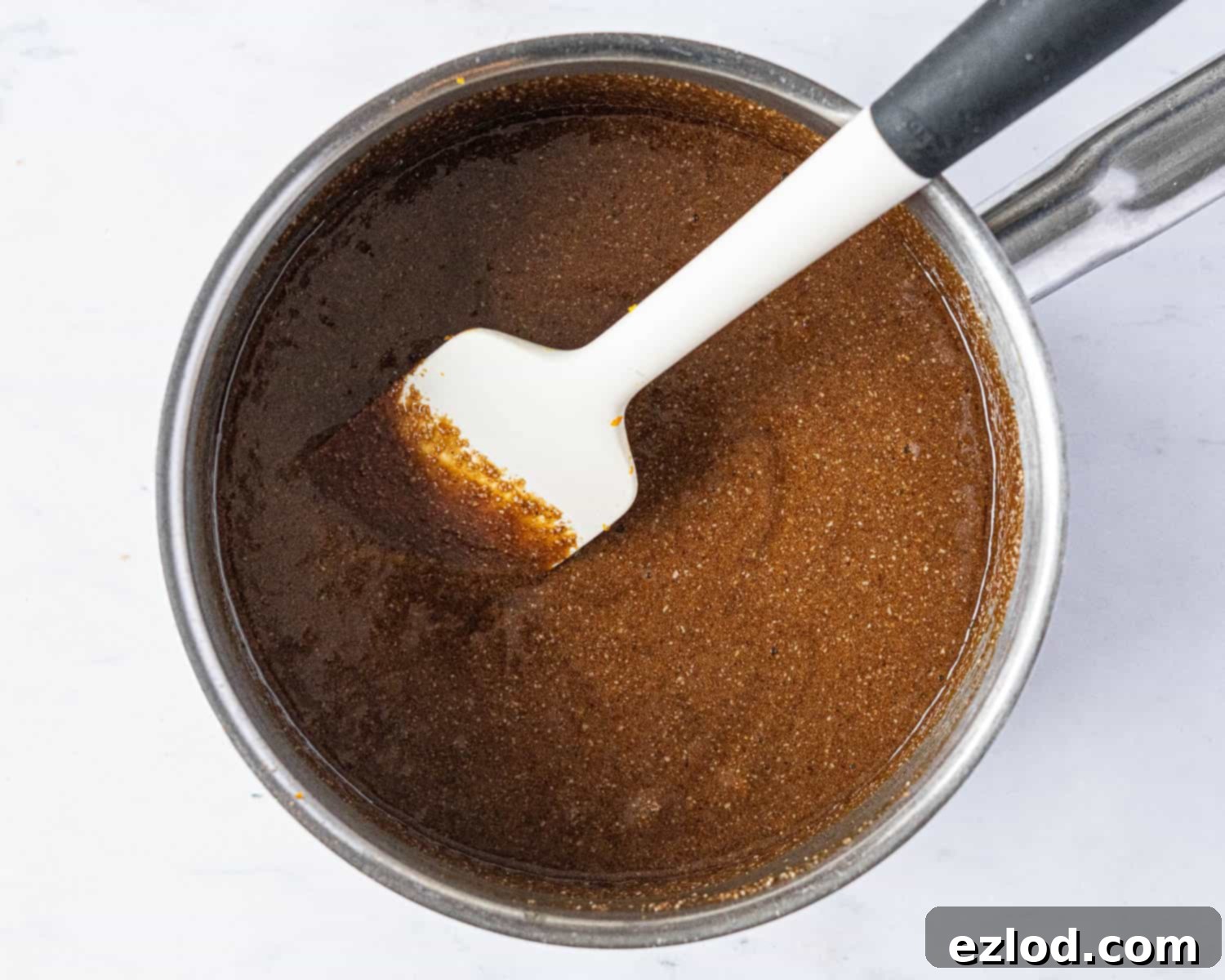 Step 2: Adding the aromatic spices and other flavorings to the melted wet ingredients for vegan Lebkuchen.