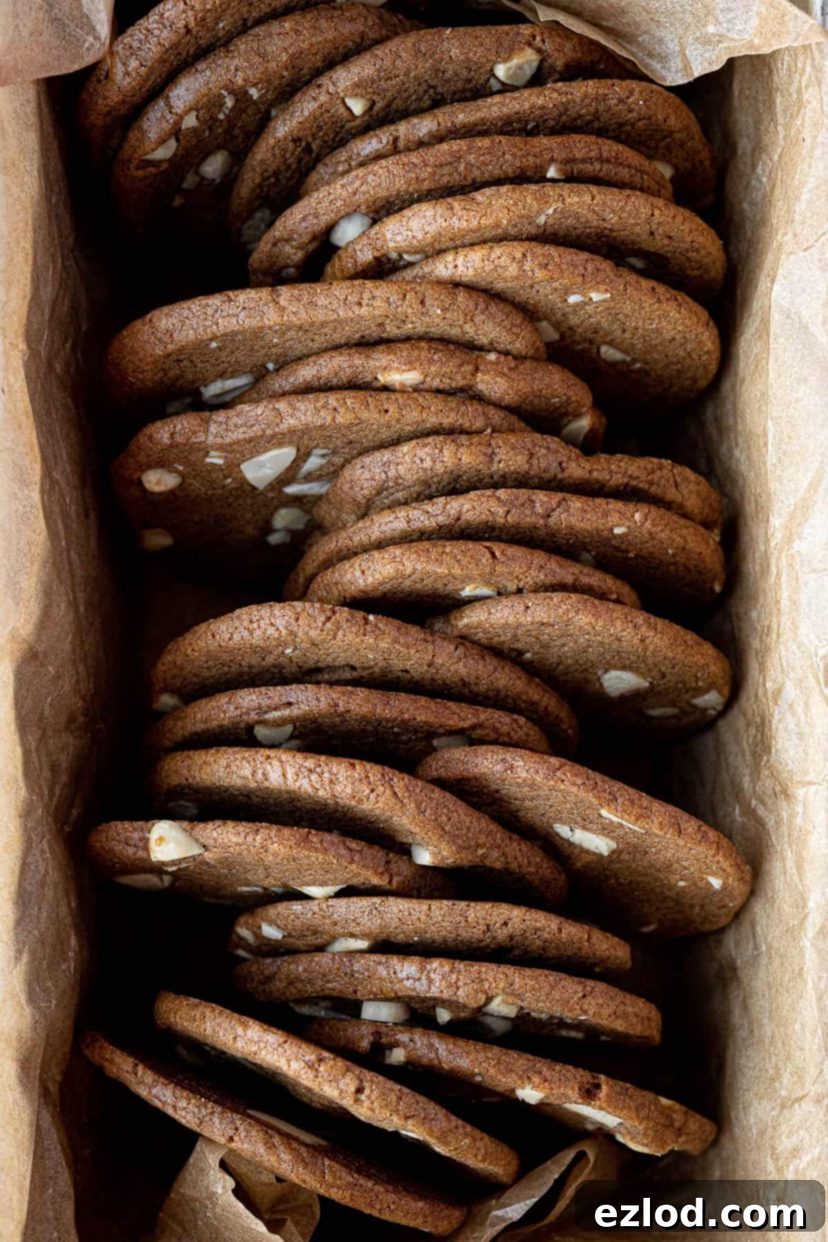Close-up view of vegan brunkager neatly stacked in a loaf tin, highlighting their uniform shape and appealing brown color.
