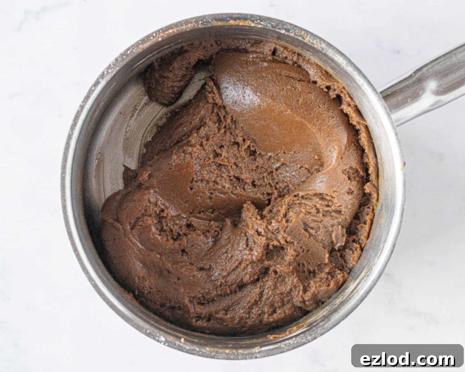 Step 3 in making vegan brunkager: the smooth, well-combined dough in the pan after the flour has been fully incorporated.
