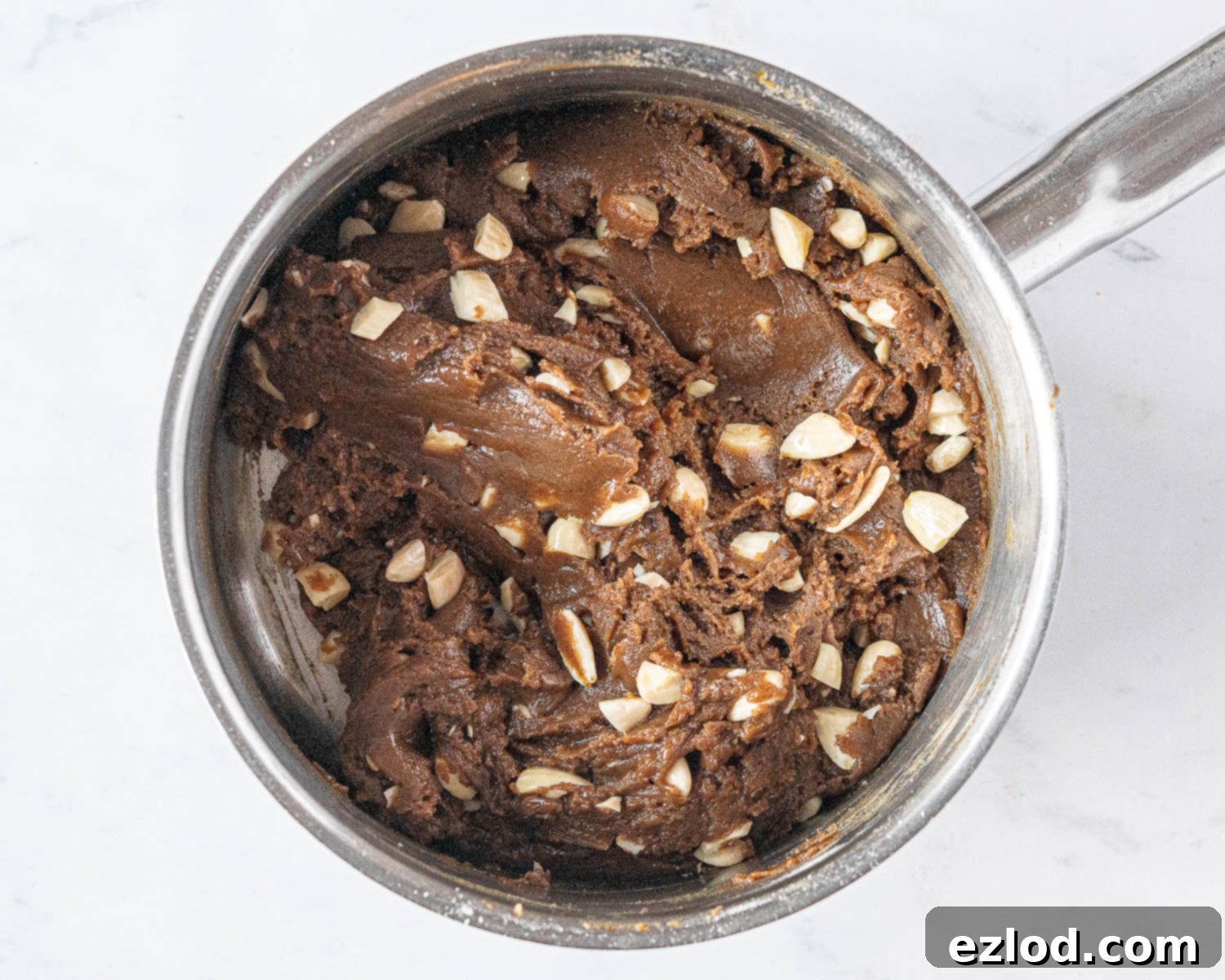 Step 4 in making vegan brunkager: blanched almonds being stirred into the prepared dough, adding texture and nutty flavor.