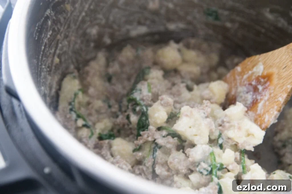 An Instant Pot filled with the delicious sausage and cauliflower casserole, ready to be enjoyed as a healthy and quick dinner.