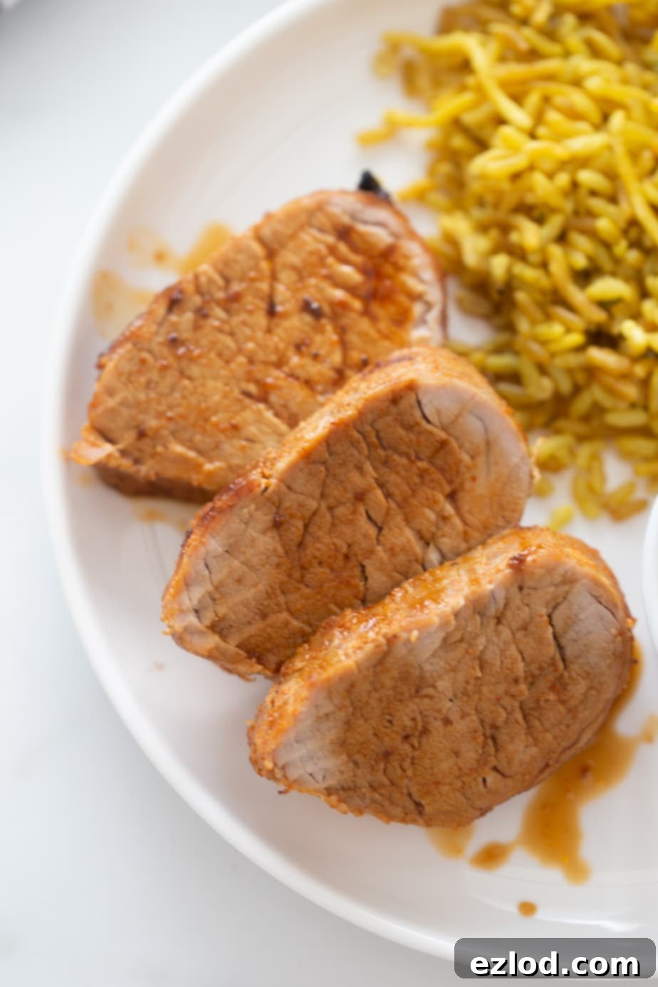 Overhead image of sliced pork tenderloin with delicious au jus drizzled over top!