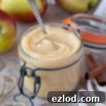 Vegan apple curd in a glass jar with apples and twine, a smaller image for the recipe card.