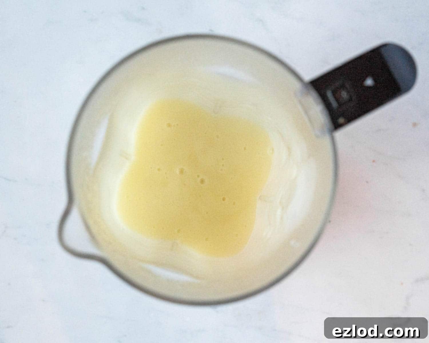 A smooth, creamy apple mixture in a blender, after being processed to a fine puree for the vegan apple curd.