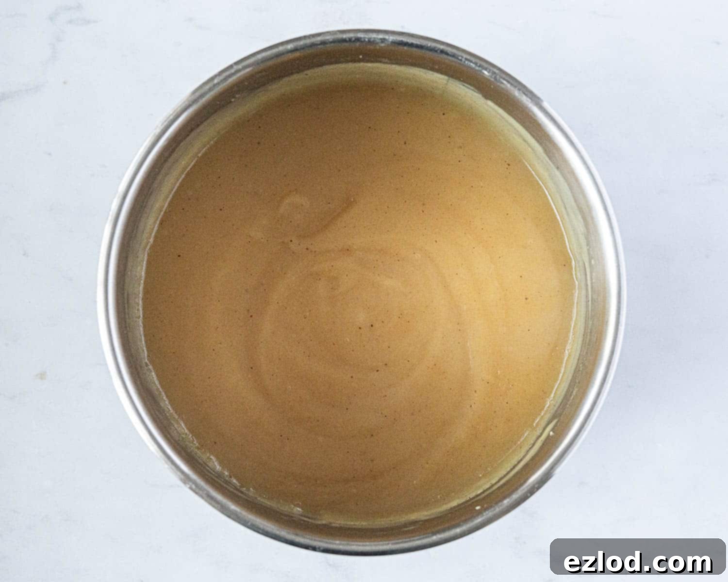 The finished vegan apple curd, thick and smooth, simmering gently in the saucepan, perfectly cooked and spiced.
