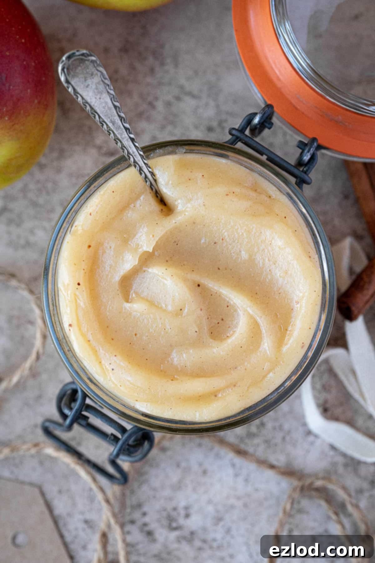 Top-down shot of a glass jar filled with luscious vegan apple curd. Its smooth texture and vibrant color invite a taste.
