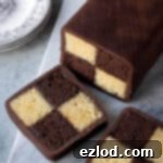 Decadent Vegan Chocolate Orange Battenberg 18 Chocolate orange Battenberg cake on a marble board with two slices cut.