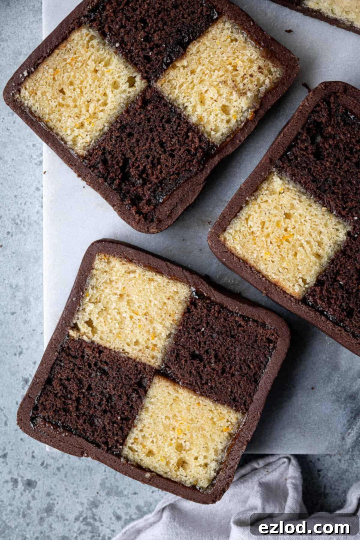 Decadent Vegan Chocolate Orange Battenberg 3 Close up of perfectly cut slices of vegan chocolate orange Battenberg cake, showing the alternating chocolate and orange sponge squares.