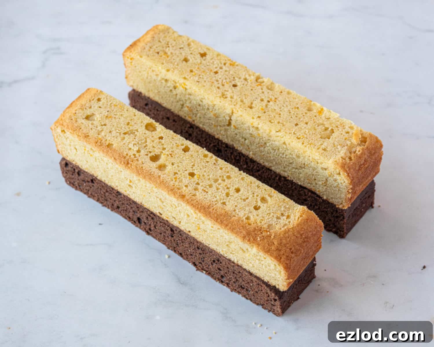 Decadent Vegan Chocolate Orange Battenberg 10 Step 6: Trimming the baked chocolate and orange cake layers to achieve even height and straight edges before slicing.