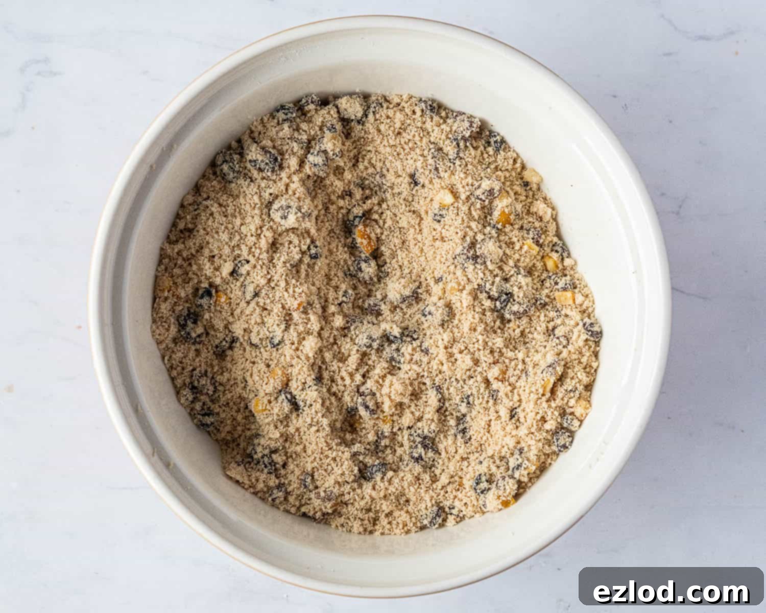 Step 2: Dried fruit being added to the flour and butter mixture.