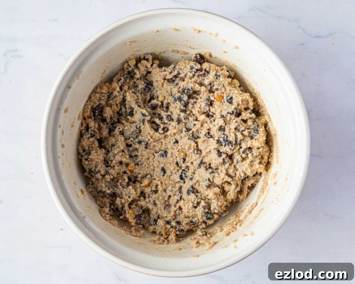 Step 3: Non-dairy milk being added to the fruit cake batter, which appears slightly split.