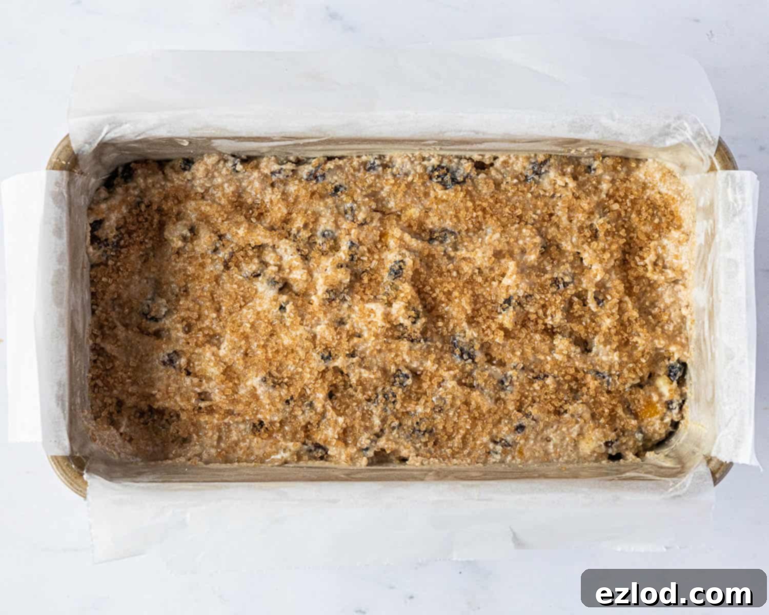 Step 4: The fruit cake batter scraped into a lined loaf tin, sprinkled with Demerara sugar, ready for baking.