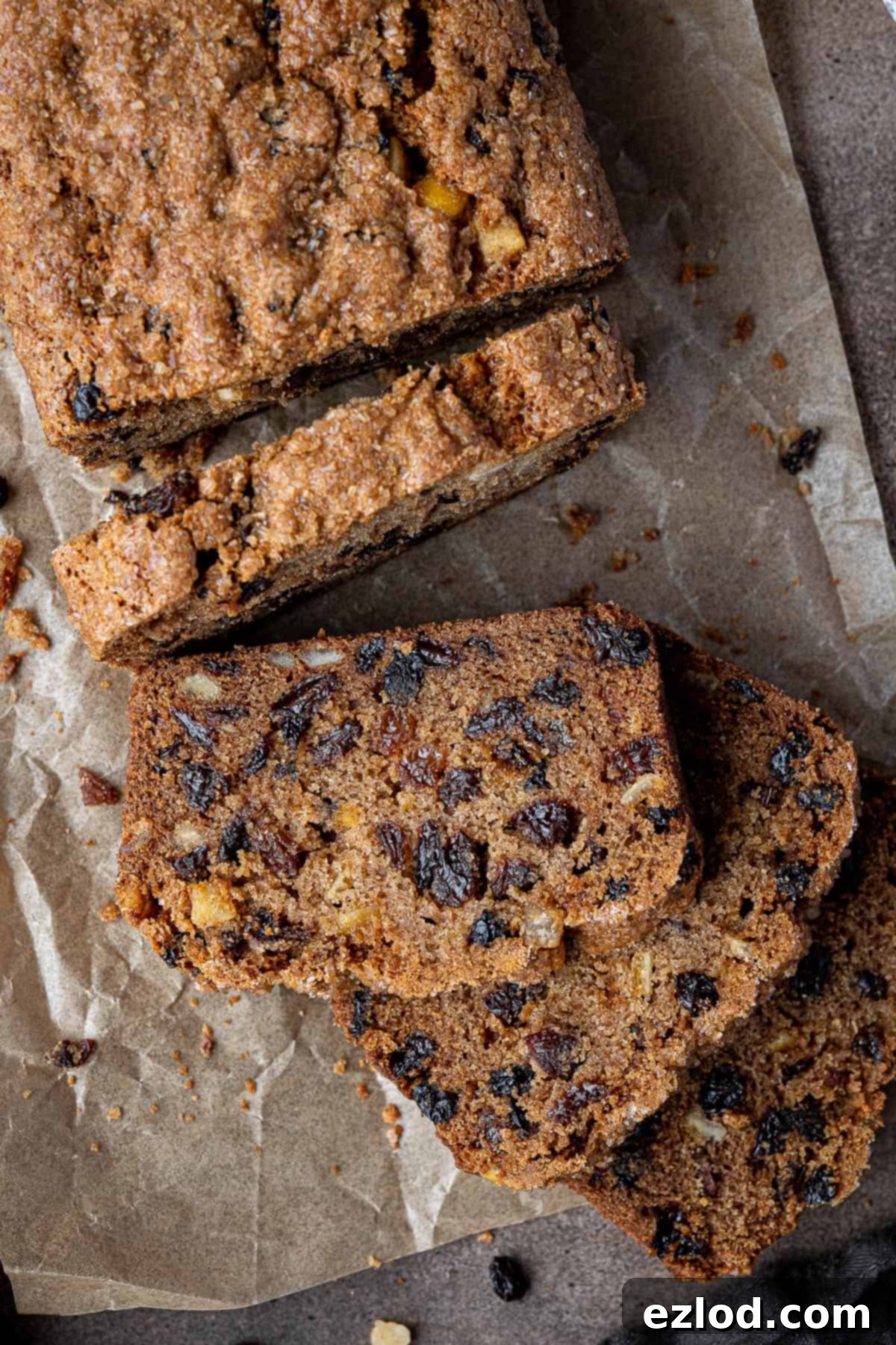 Close up of beautifully sliced pieces of vegan fruit cake loaf on a cooling rack.