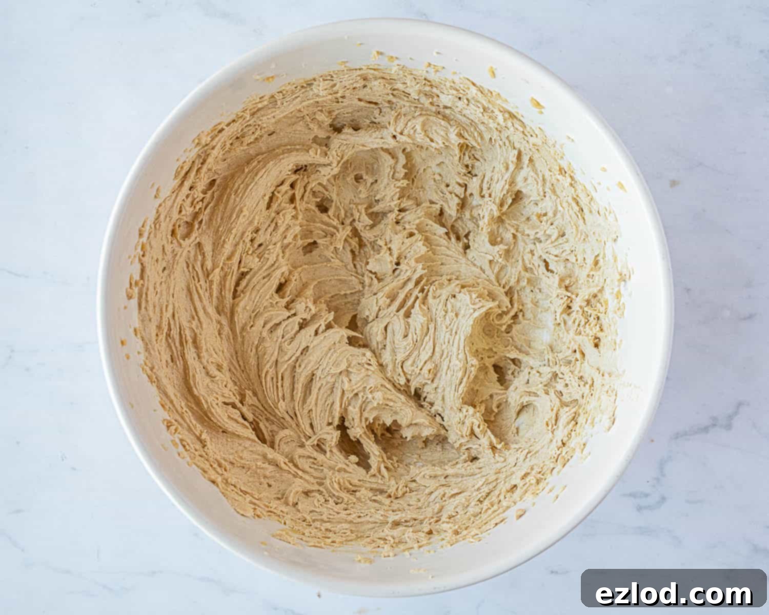 Step 1: The creamy, whisked butter, peanut butter, and sugar mixture in a bowl, ready for dry ingredients.