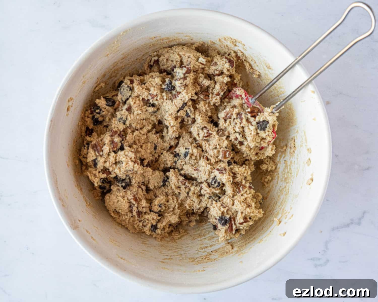 Step 4: Chocolate chips and chopped nuts being gently mixed into the cookie dough.