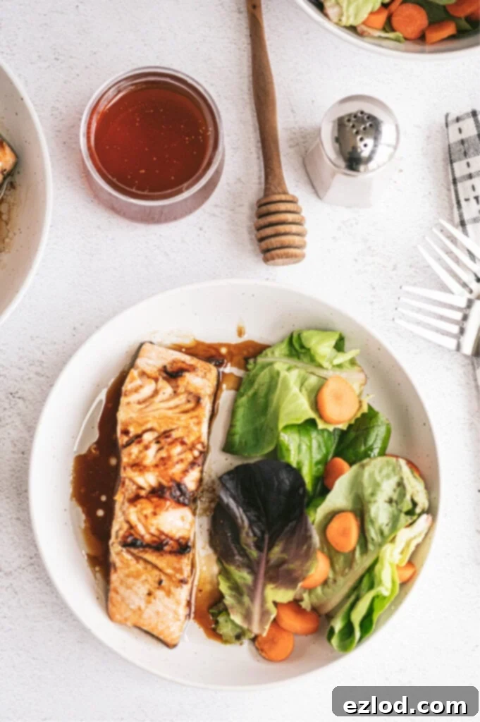 honey glazed salmon oven baked on a white plate with side salad