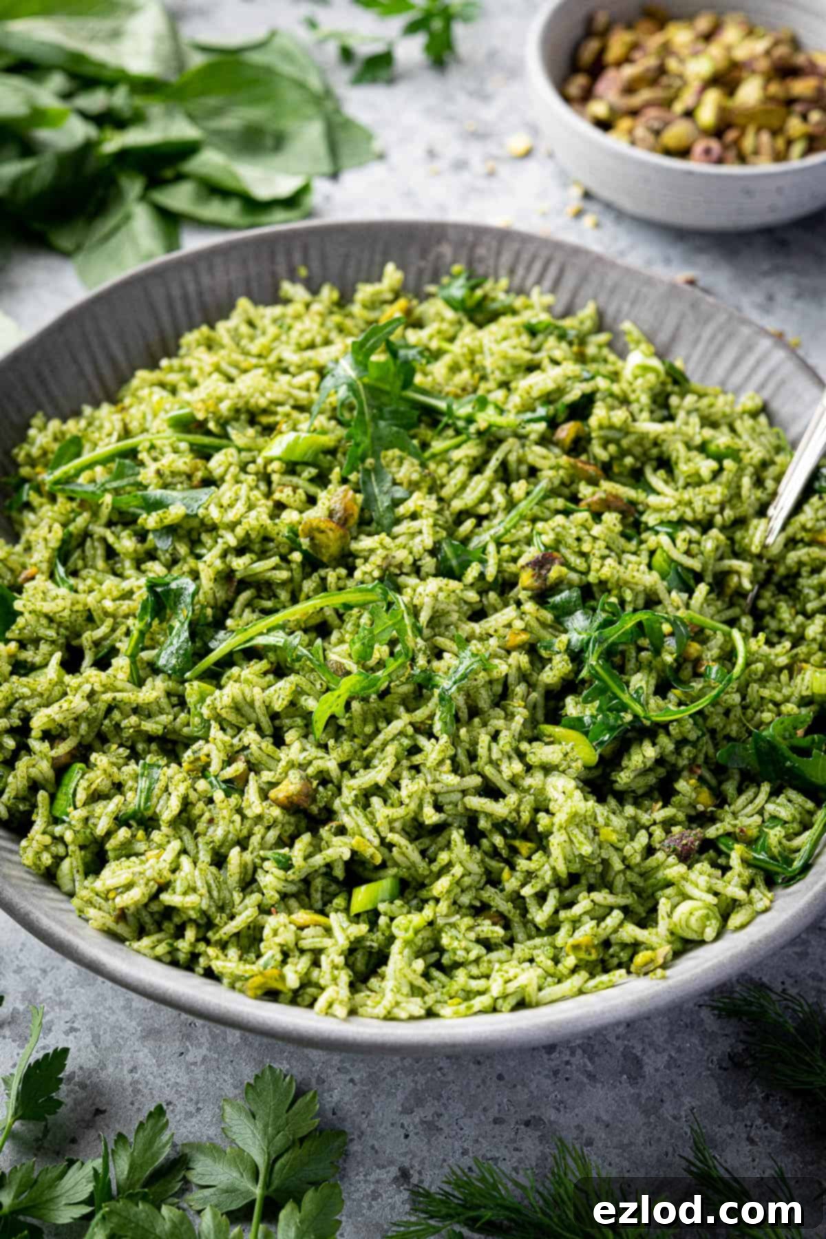 A beautifully presented bowl of herby rice salad against a clean grey background, showcasing its appetizing appeal.