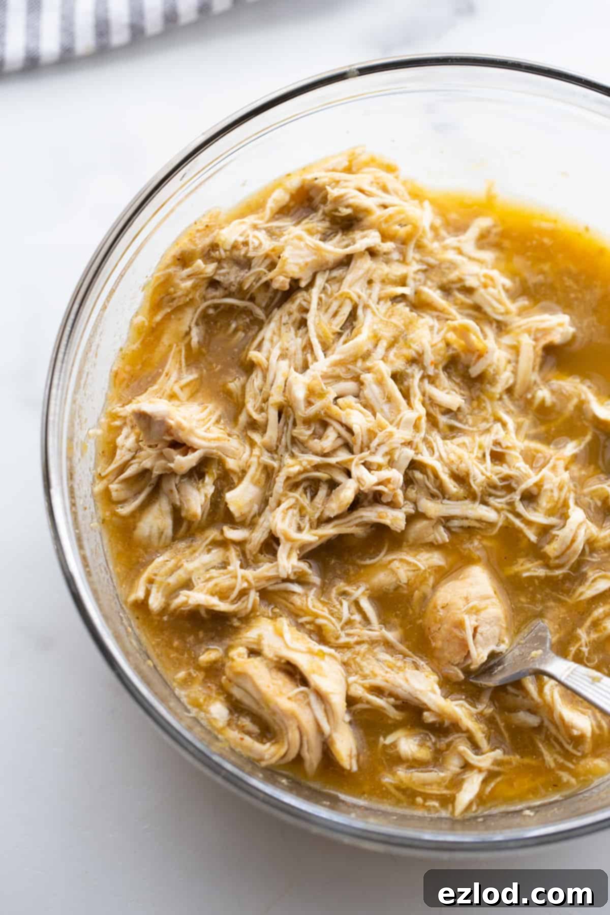 Effortless Salsa Verde Chicken Instant Pot or Slow Cooker 4 Slow cooker pot filled with raw chicken breasts seasoned with taco seasoning and covered in green salsa verde sauce, ready to be cooked.