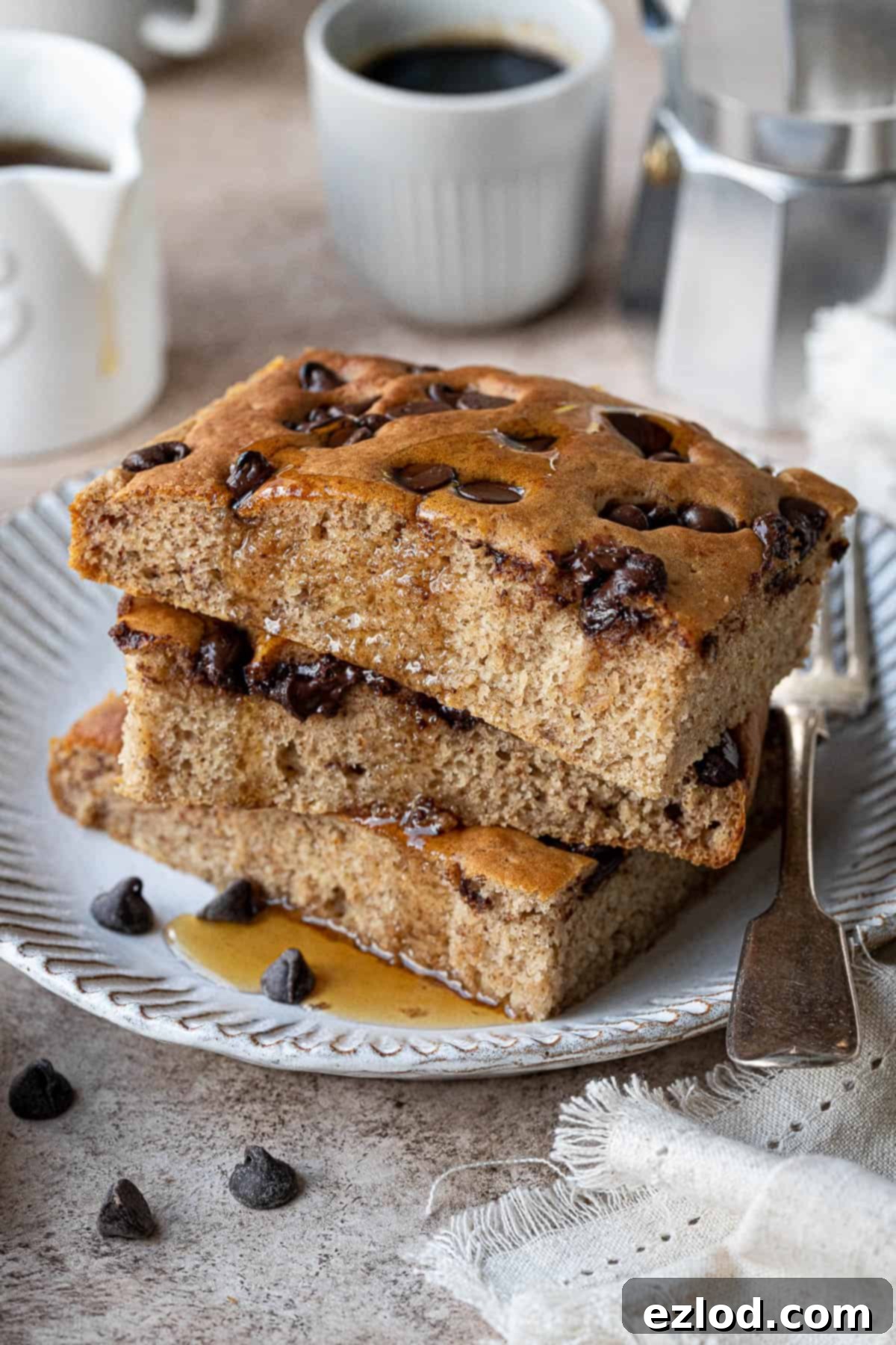 A stack of fluffy sheet pan banana pancakes on a white plate, ready to be served.