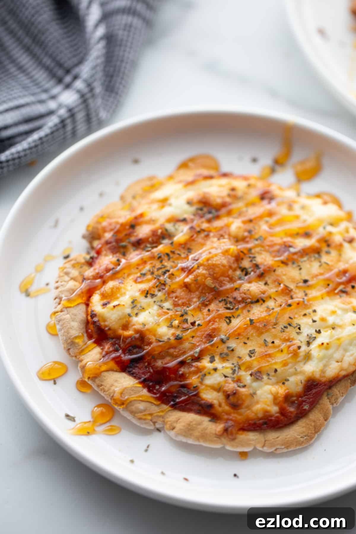 Creamy Hot Honey Ricotta Pizza 2 A personal hot honey pizza with melted mozzarella and dollops of ricotta, generously drizzled with spicy honey and fresh herbs, ready to be enjoyed.