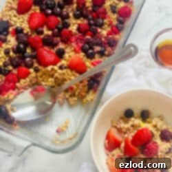 One Pan Baked Oatmeal with fresh berries and a drizzle of maple syrup.