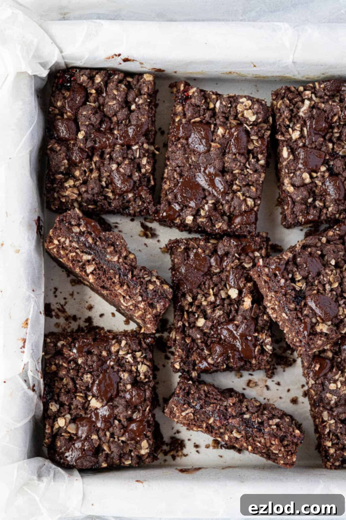 Chocolate raspberry crumble bars in a parchment lined tin.