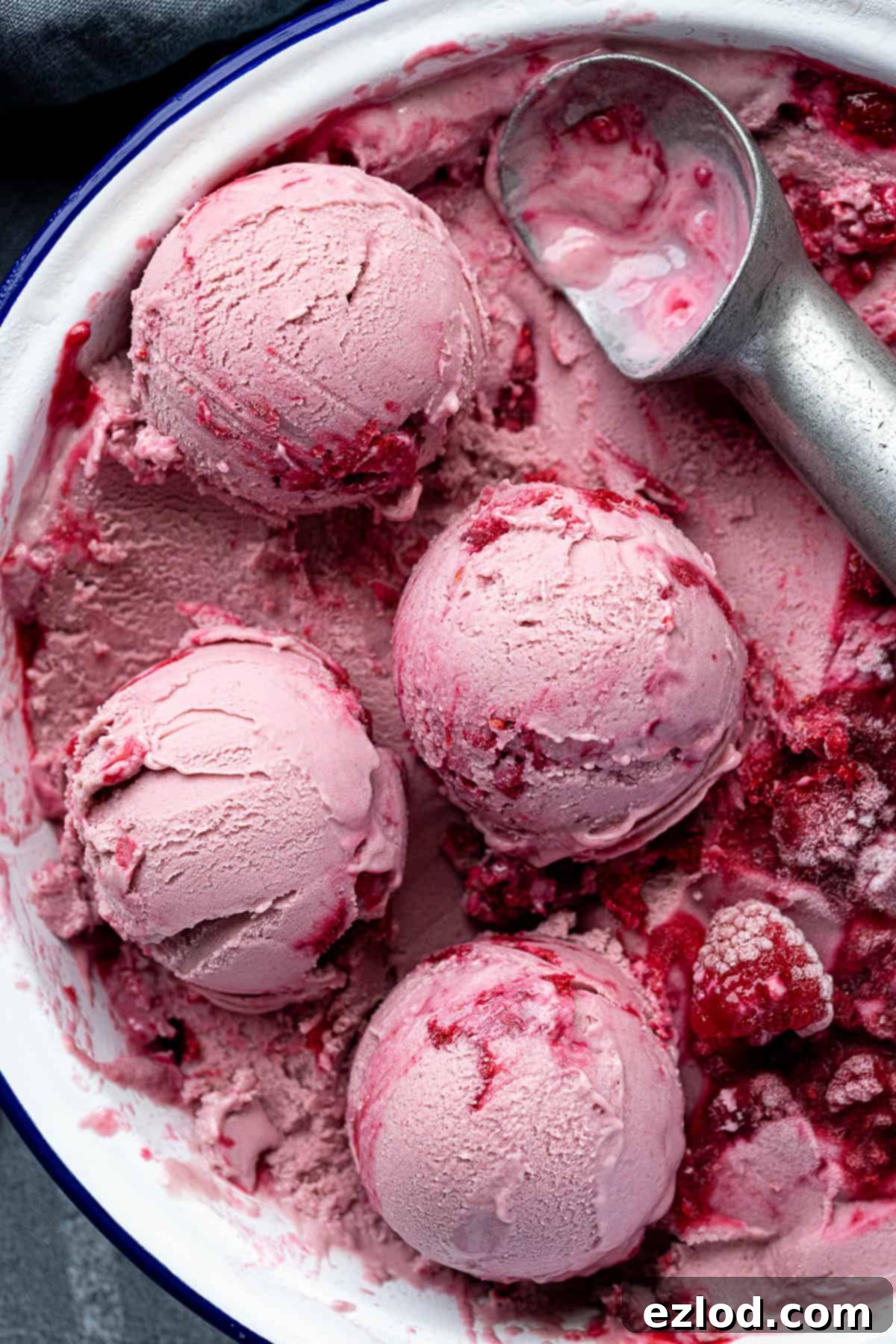 Multiple scoops of vegan raspberry ice cream arranged in a pie dish.