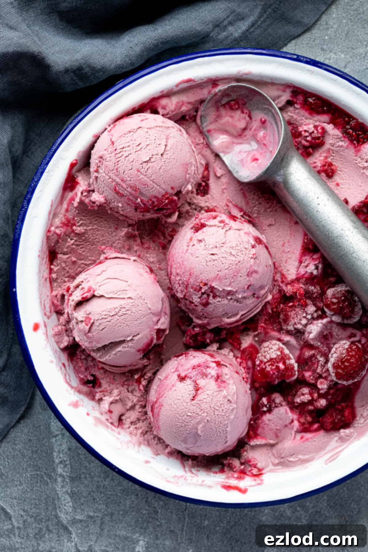 A dish filled with scoops of vegan raspberry ice cream.