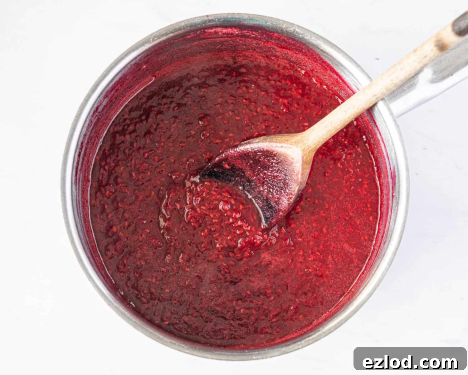 Step 1: The cooked raspberry compote simmering in a pan.