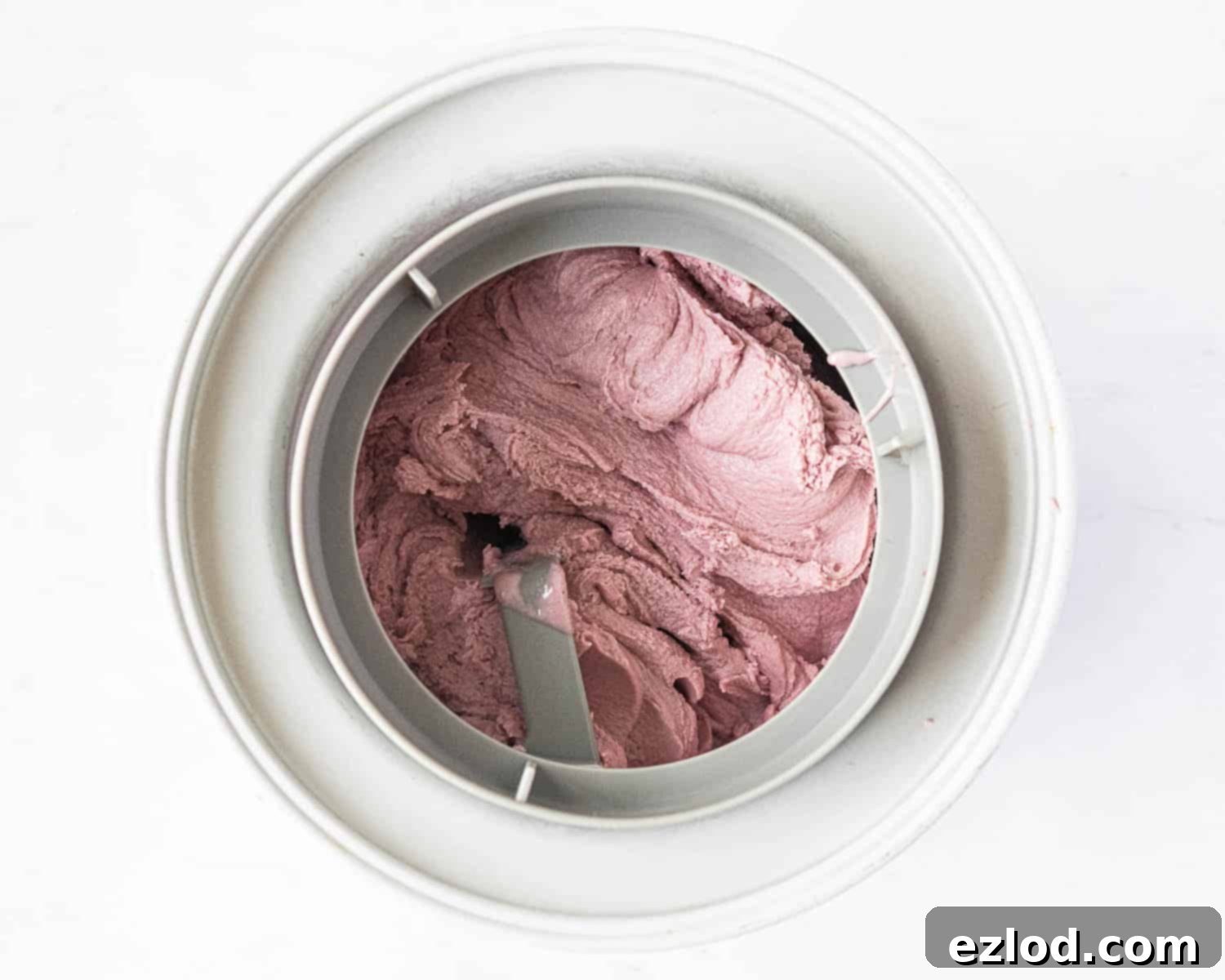 The churned ice cream in an ice cream maker, resembling soft serve.