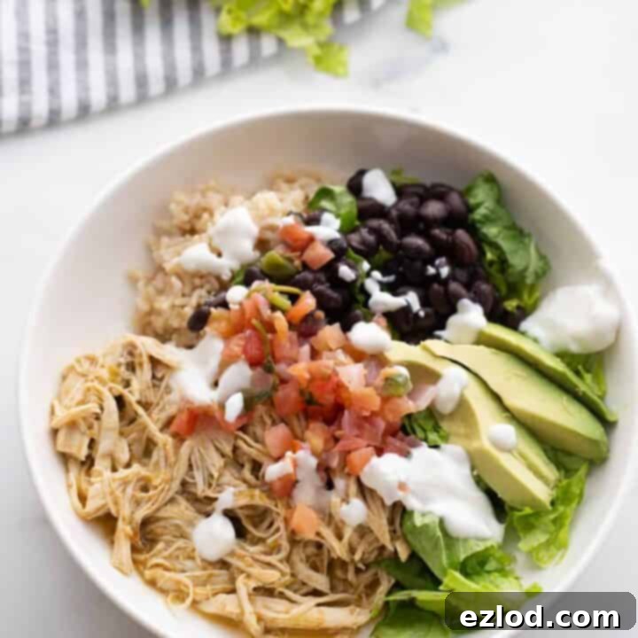 Easy Salsa Verde Chicken bowls topped with fresh avocado, pico de gallo, and Greek yogurt, served over brown rice and arugula