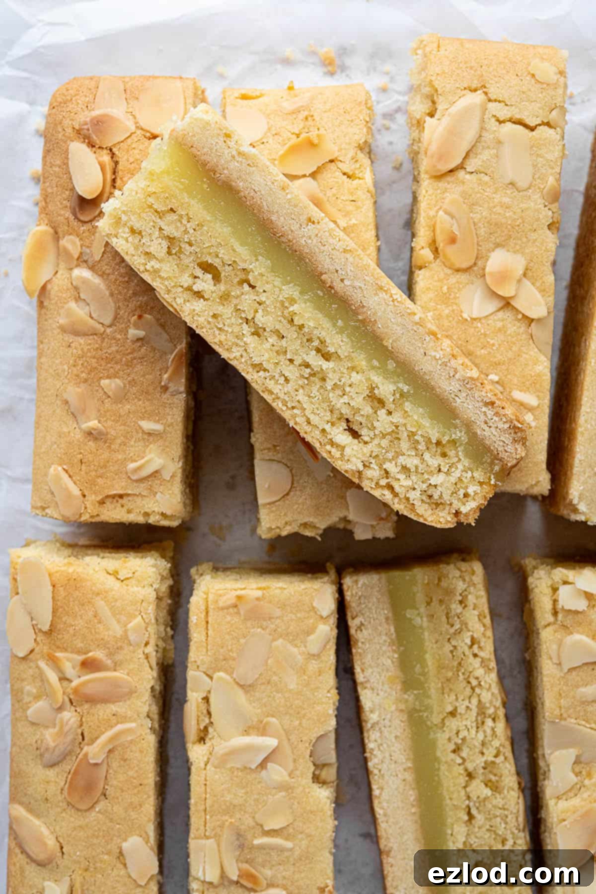 Zesty Vegan Bakewell Bliss 4 Close-up of a single vegan lemon Bakewell slice, showing the perfect layering and a sprinkle of flaked almonds on top.