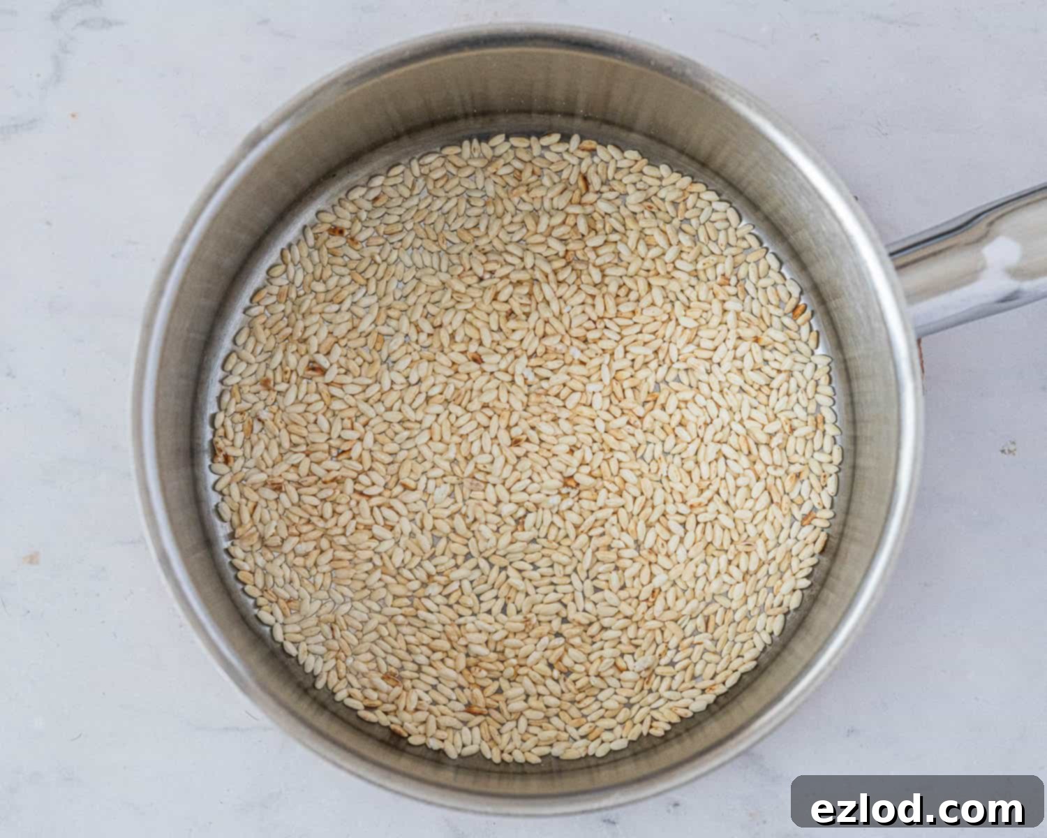 Step 1: Short-grain rice toasting in a saucepan, turning golden.