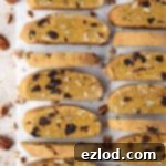 Two rows of vegan pumpkin biscotti on a sheet of baking parchment.