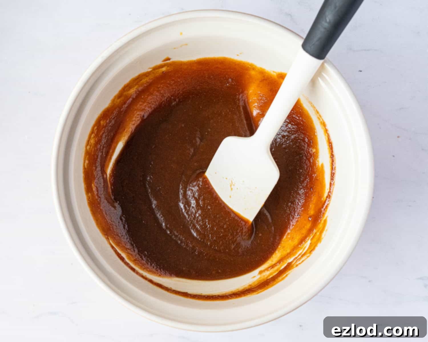 Bowl containing the wet ingredients for vegan pumpkin biscotti, freshly whisked.